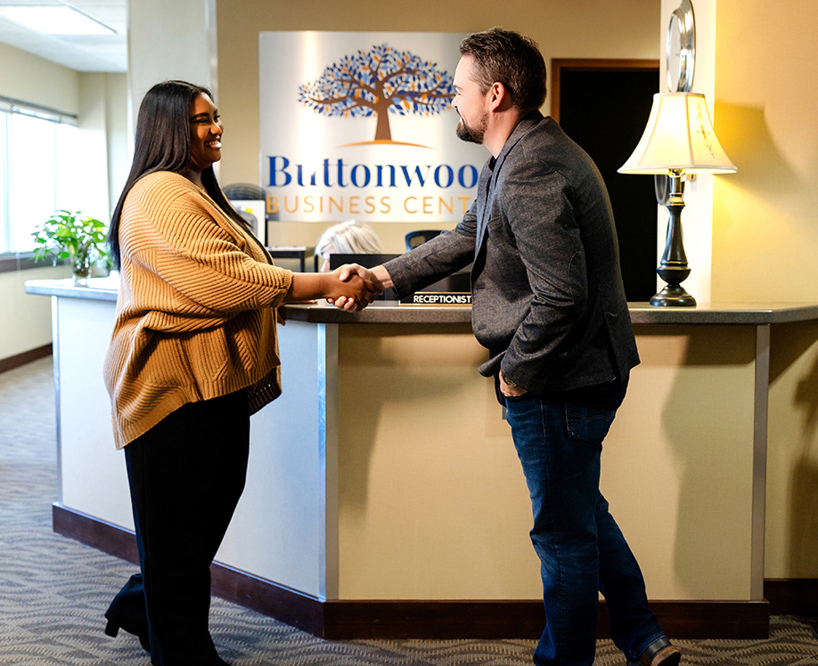 Jemika, a licensed therapist for Better Together Mental Health, greets a professionally dressed man in the lobby of the Buttonwood Business Center.