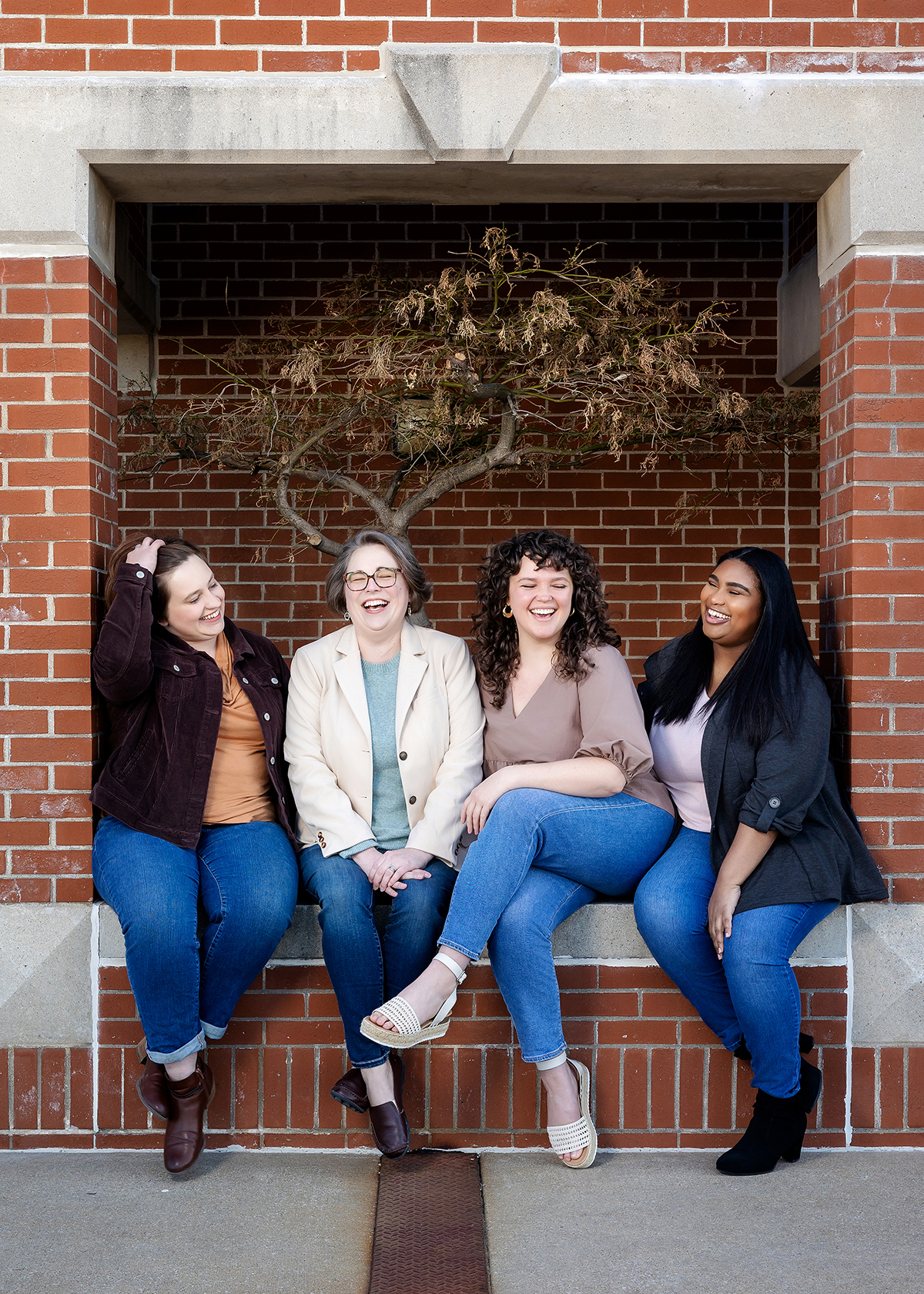The Better Together Mental Health team sits and laughs spending time together during their photoshoot. 